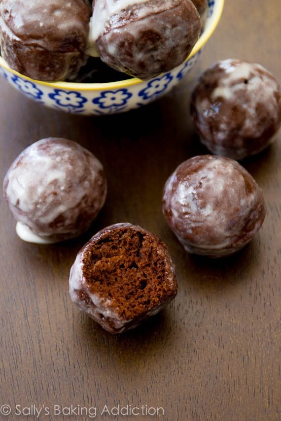 glazed chocolate donut holes with a bite taken from one