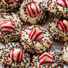 candy cane kiss sugar cookies arranged on white plate.