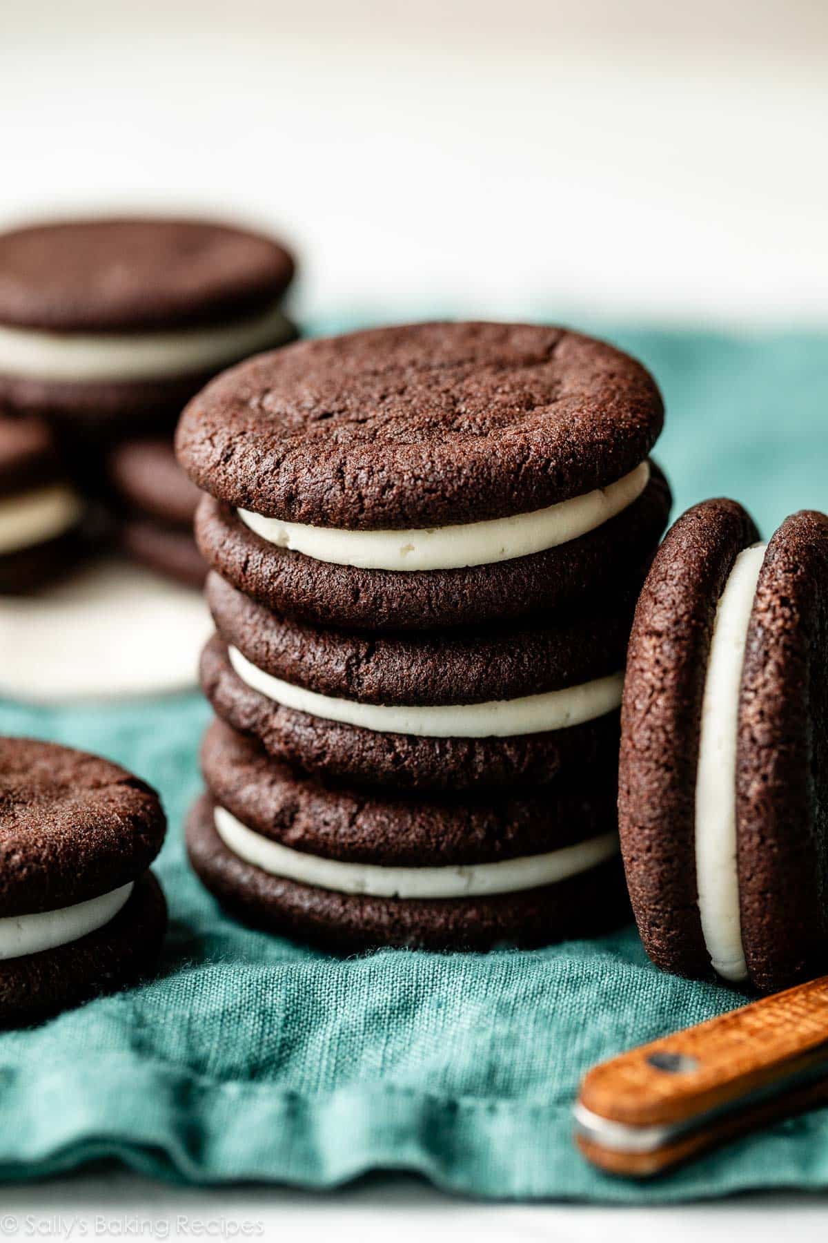 stack of 3 homemade Oreos on blue linen.