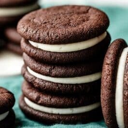 stack of 3 homemade Oreos on blue linen.