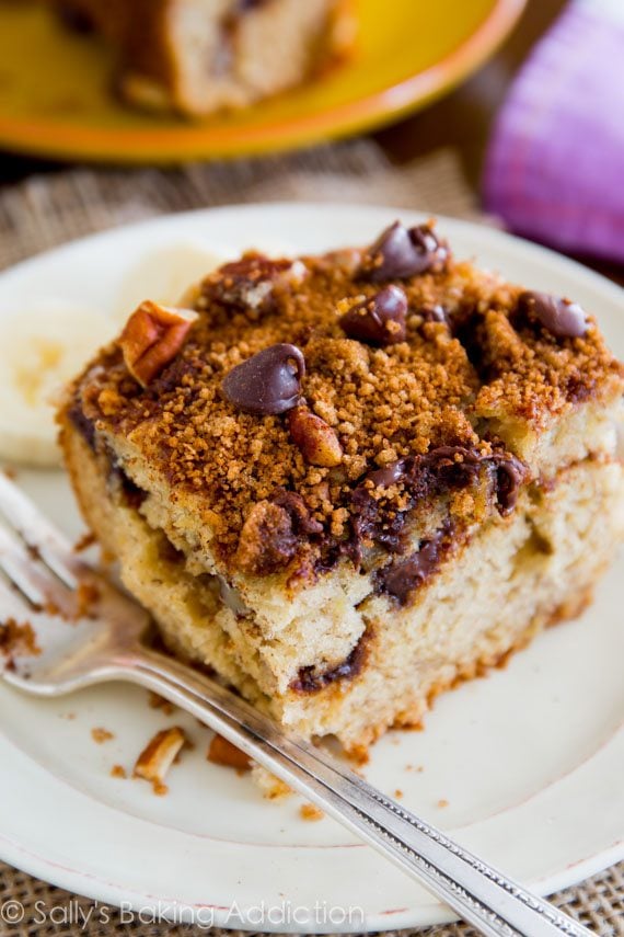 slice of banana chocolate chip crumb cake on a white plate with a fork