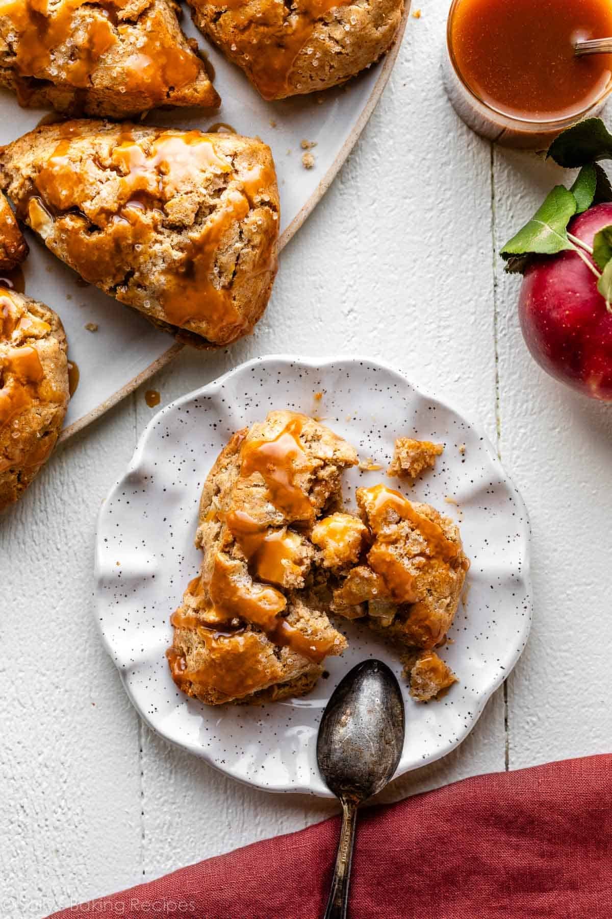 apple cinnamon scone on plate with caramel sauce on top.