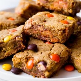 peanut butter blondies stacked on a white plate
