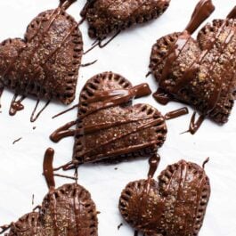 overhead image of heart shaped chocolate hand pies drizzled with chocolate topping
