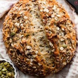 round boule of seeded bread on ivory linen.