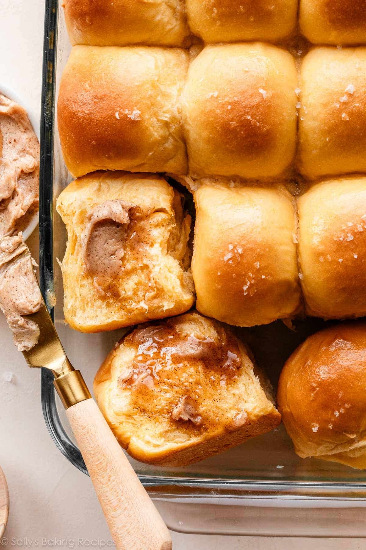 sweet potato rolls with cinnamon butter and sea salt on top in glass dish.